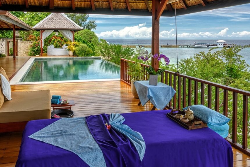 massage table set up on a deck overlooking an infinity pool and the sea