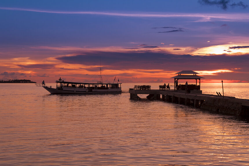 boat and jetty silhouetted against an orange sunset at Wakatobi