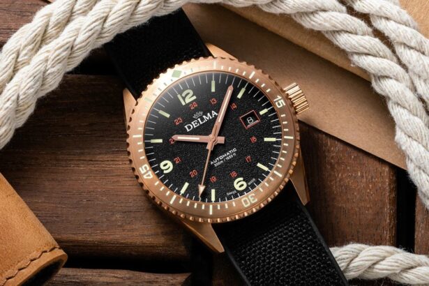 Delma Cayman automatic dive watch with a bronze case and black dial resting on wood beside rope