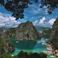Limestone cliffs ring the turquoise lagoon and dive boats at Coron Bay, Palawan