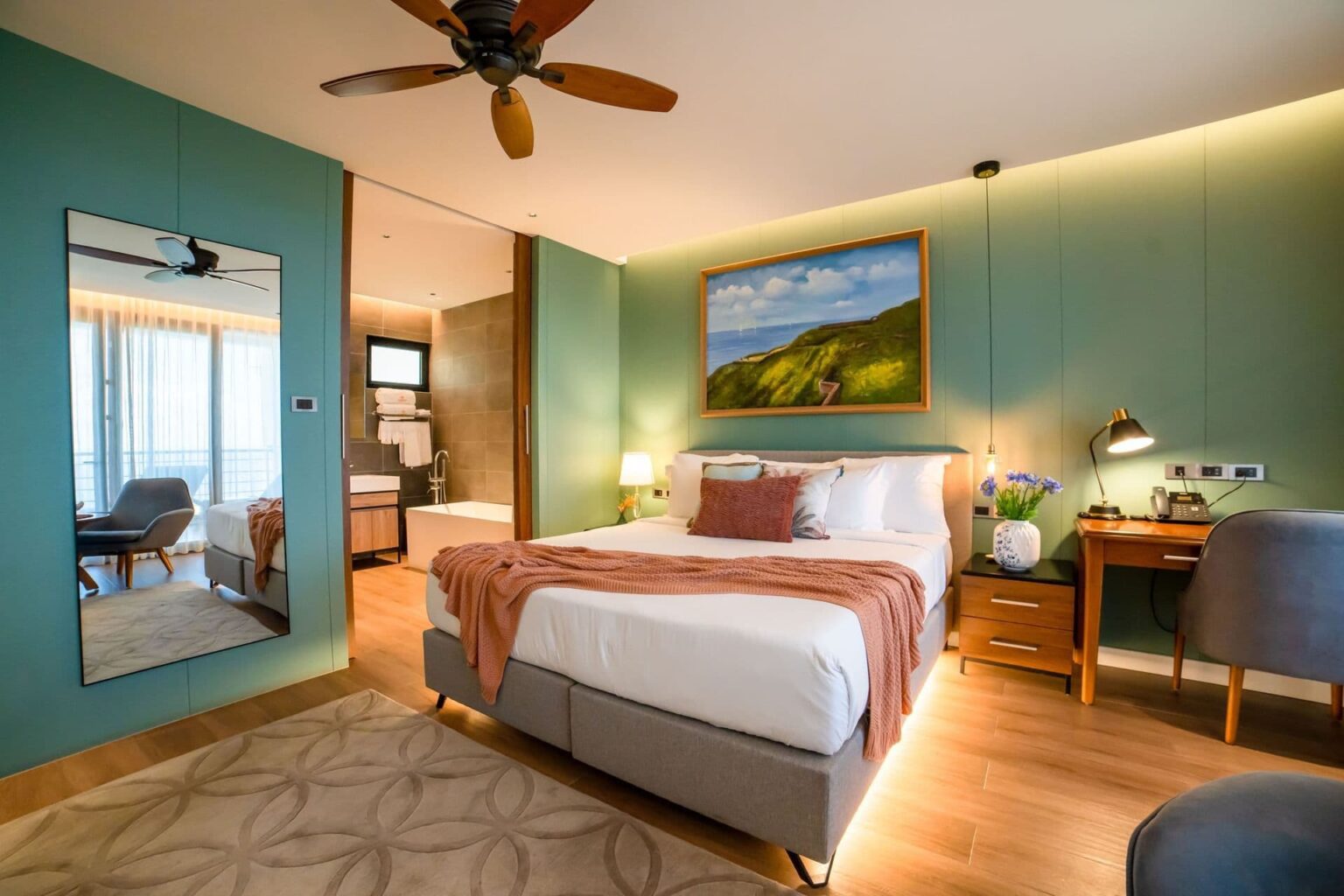 deluxe ocean view room with a king bed, mirrored wall and open bathroom at Golden Rock Resort