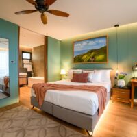 deluxe ocean view room with a king bed, mirrored wall and open bathroom at Golden Rock Resort