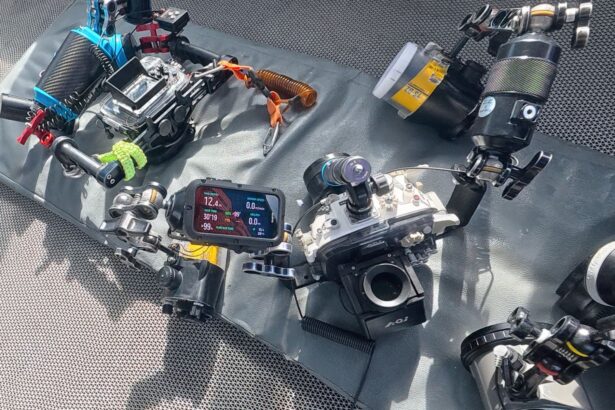 Suunto Nautic mounted on a camera float arm beside underwater housings on the boat deck