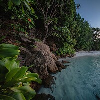 Rocky tropical beach cove at dusk with the Emperor Divers no hidden extras logo