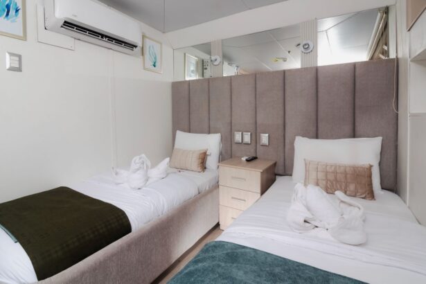 Twin cabin aboard the Humboldt Explorer with made-up beds and mirrored headboard wall