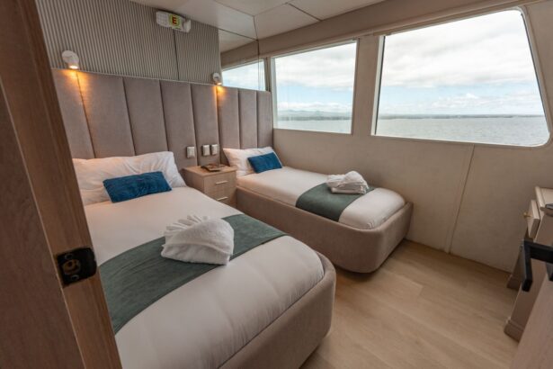 Twin cabin on the Humboldt Explorer with made beds, towel swans and a large window seat