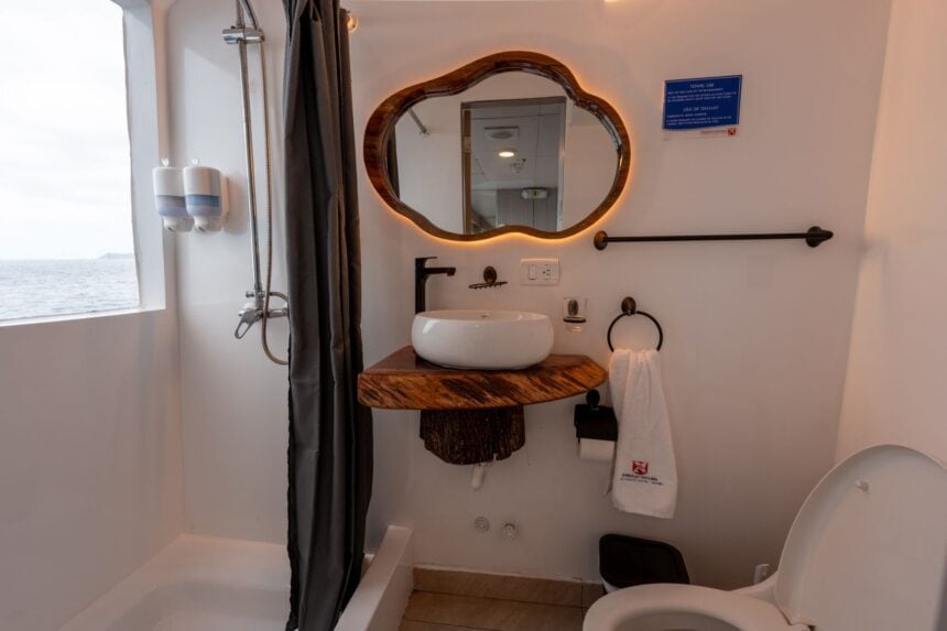Compact ensuite bathroom aboard the Humboldt Explorer with wood-framed mirror and vessel sink