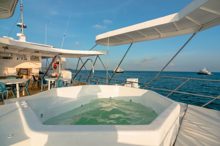 Outdoor jacuzzi tub on the top deck of the Humboldt Explorer with other liveaboards visible at sea
