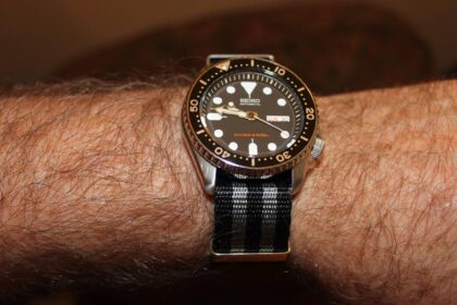 DIVEIN reviewer wearing the Seiko SKX007 on a striped NATO strap, black dial and dive bezel in view
