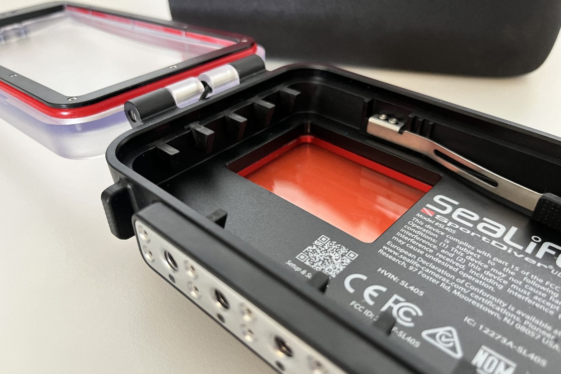 SeaLife SportDiver Ultra opened with its lid off, showing the red filter and hinge tabs inside