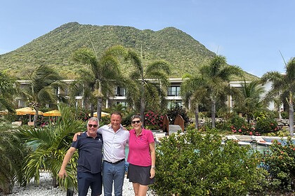 Mike Harterink, Peter Barnhoorn and Marieke van de Wetering standing together beside the pool at Golden Rock Resort, with The Quill volcano rising behind them on St. Eustatius