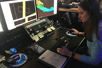 Explorer-in-Training Cassie Ferrante working with multibeam sonar data on a research ship