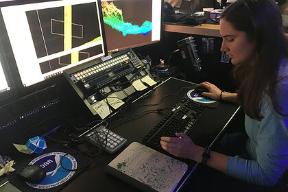 Explorer-in-Training Cassie Ferrante working with multibeam sonar data on a research ship