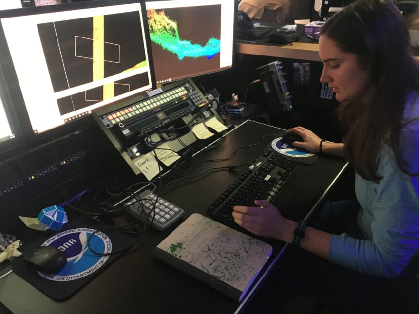 Explorer-in-Training Cassie Ferrante working with multibeam sonar data on a research ship